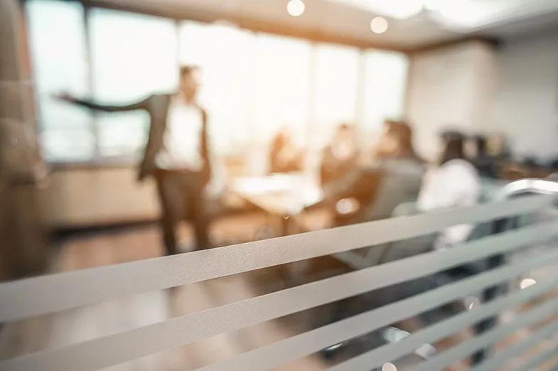 Blick in Meetingraum mit Sprecher und Zuhörern