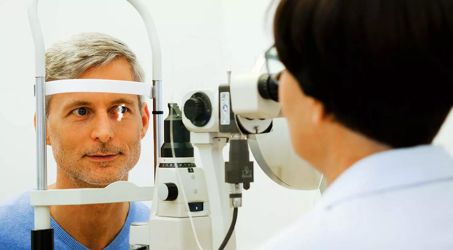 Analyse Kunde schaut beim Optiker in eine Spaltlampe