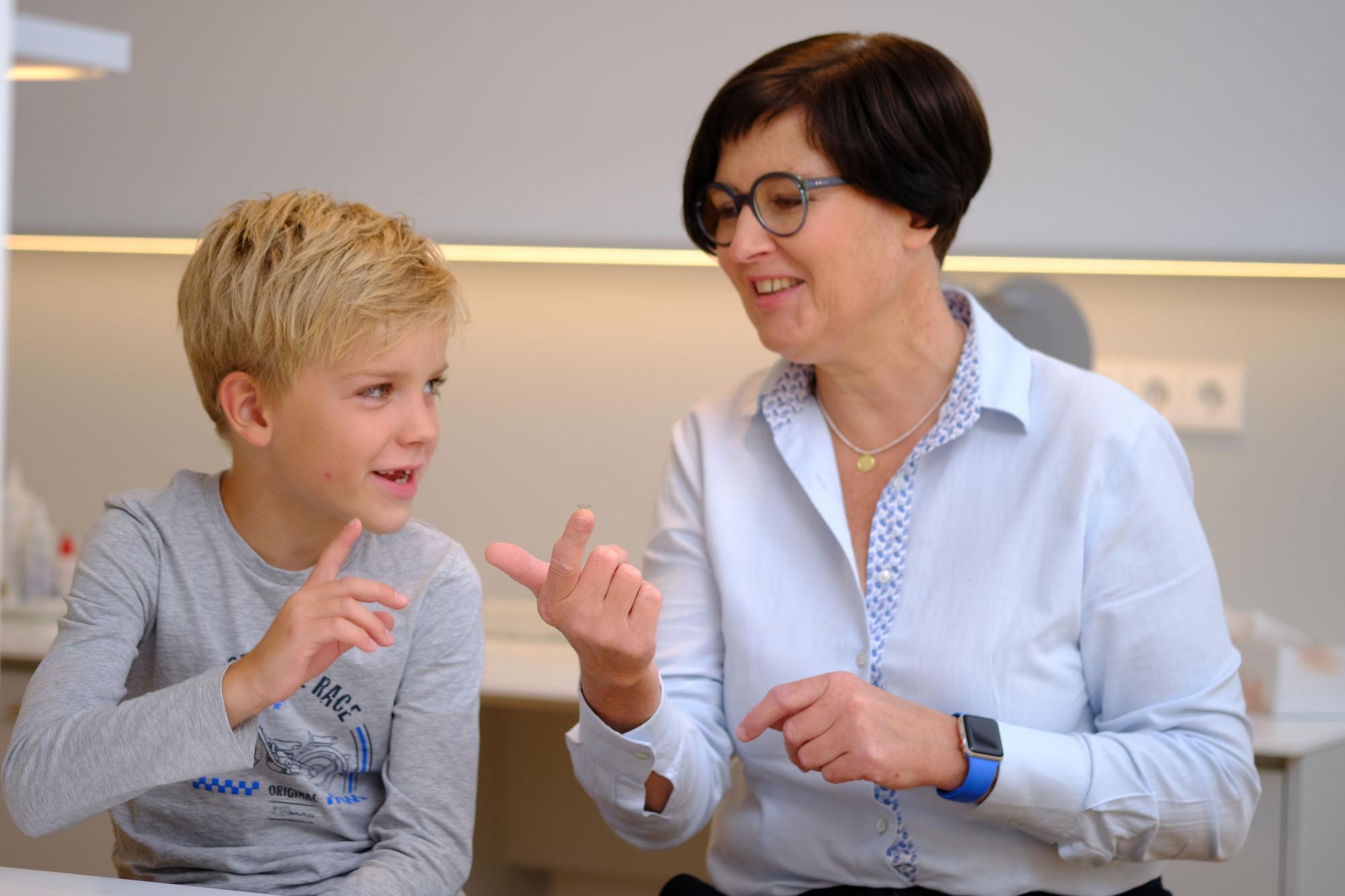 Augenoptikerin erklärt Jungen Kontakltinsen für Kinder