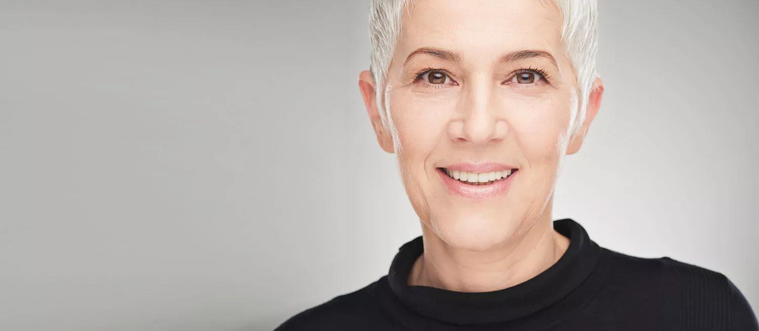 multifokal Frau mit grauem Haar lächelt in die Kamera